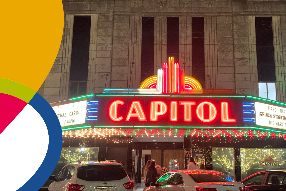 Exterior of the Capitol at night with green and red lights under the marquee