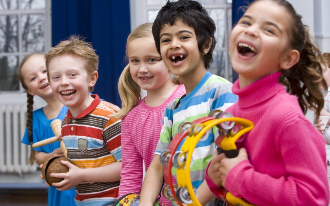 photo of laughing children holding musical instruments