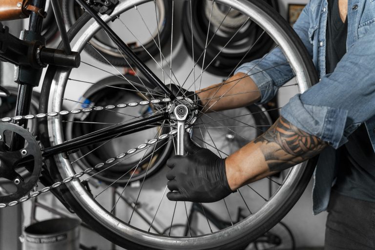 Person performing maintenance on the wheel of a bicycle