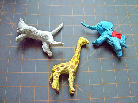 Three paper mache animals on a grid