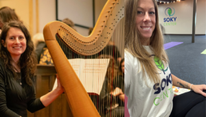 Image of a woman with harp and a yoga instructor in the studio